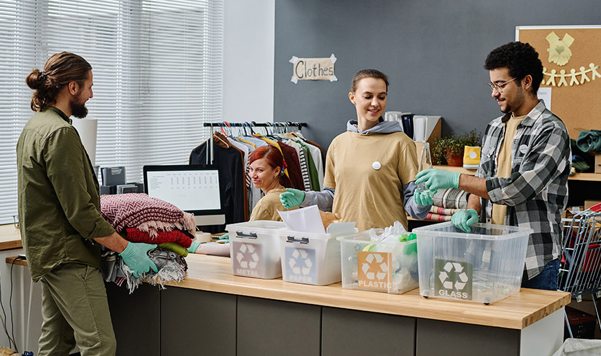 group-of-volunteers-sorting-trash-in-garbage-bins--6RKCM8W